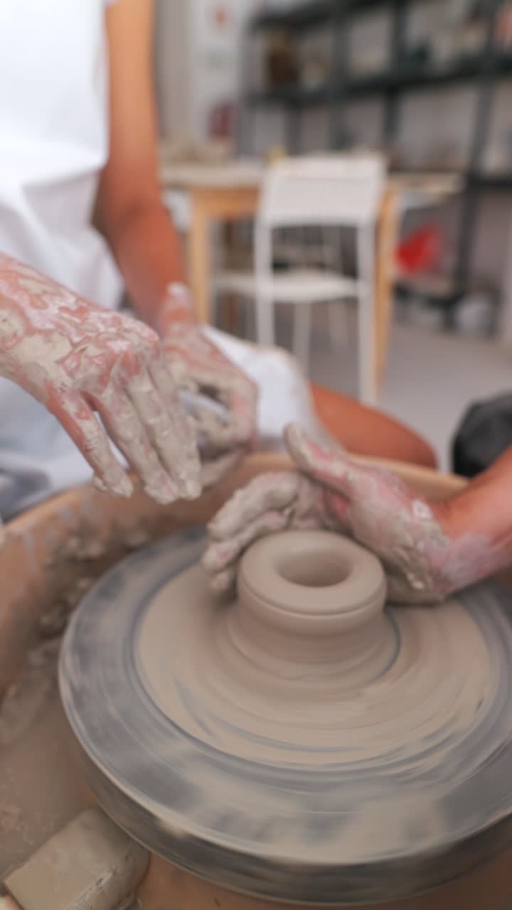 manos moldeando arcilla en una rueda de cerámica