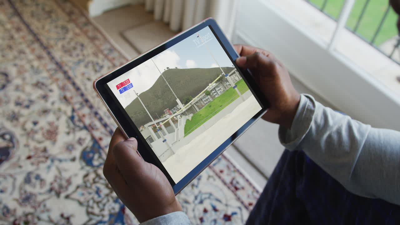 Composite of man sitting at home, watching athletics high jump event on tablet