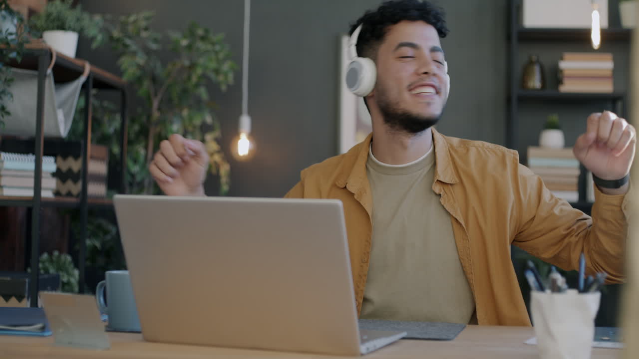 Young Man Working From Home and Listening to Music
