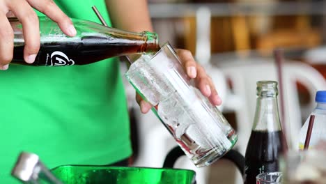 refreshing cola poured into glass with ice