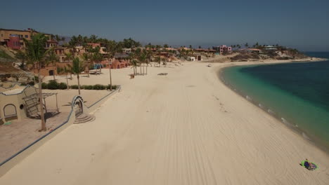 Drone-Vuela-Sobre-Imágenes-Que-Muestran-Casas-De-Playa-A-Lo-Largo-De-La-Playa-Vacía-En-Cabo-San-Lucas,-México
