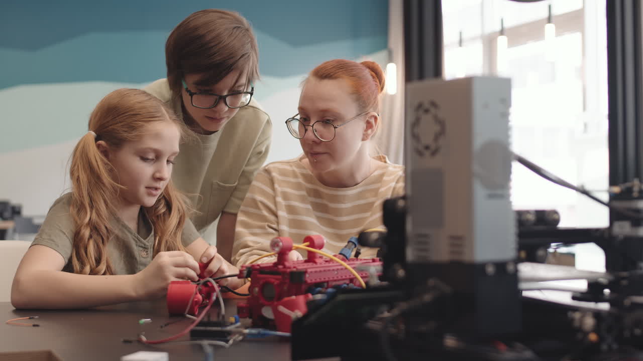 Female Teacher and Two Intelligent Teenagers Having Science Class