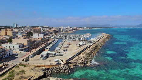 experience the beauty of can picafort's harbor and the stunning son baulo coastline. enjoy the turquoise waters and vibrant seaside scenery on this sunny day in mallorca.