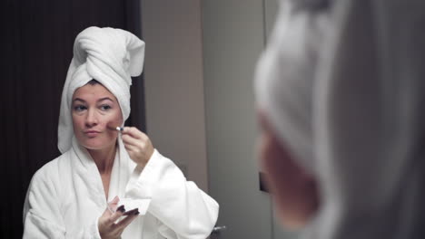 Woman-applying-blush-using-a-small-brush