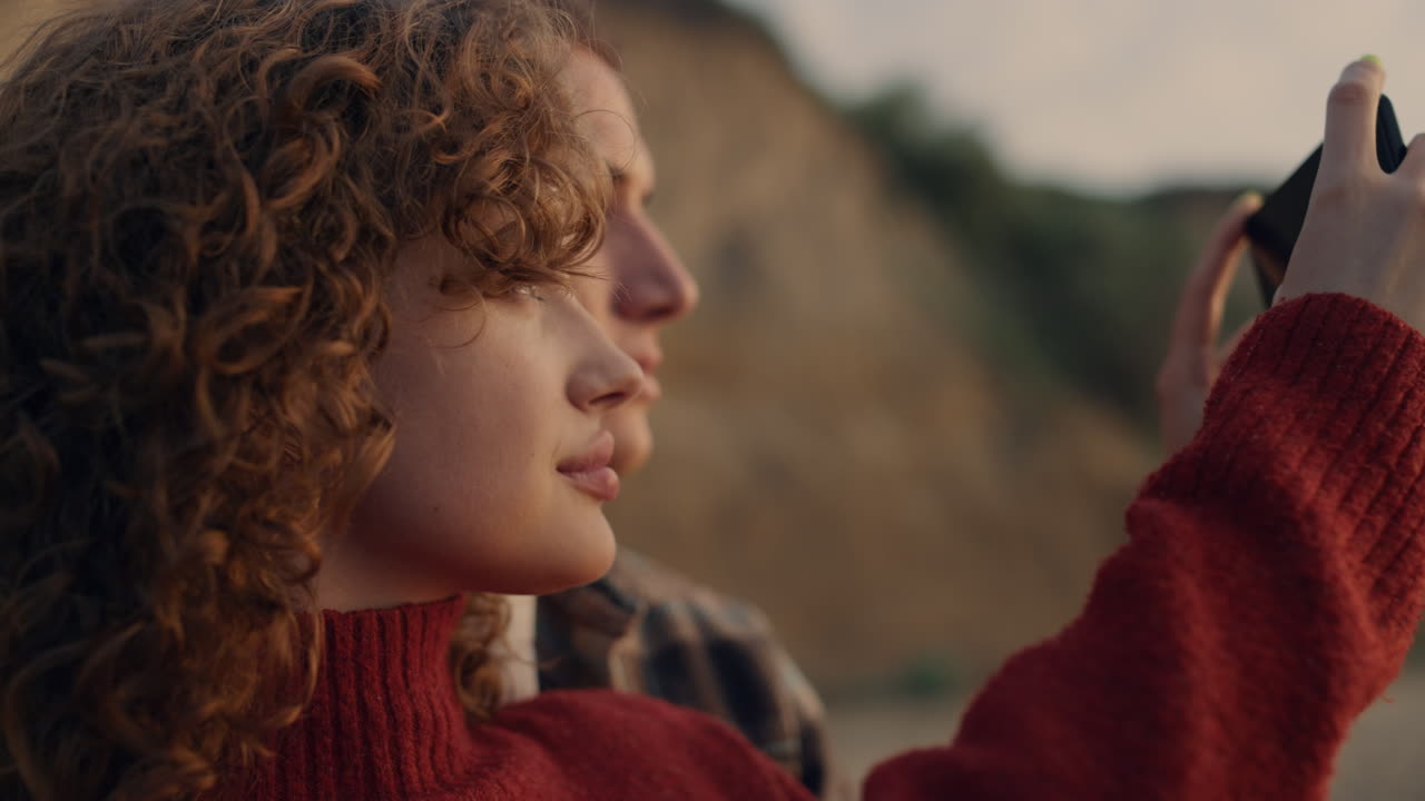 armarios relajados tomando fotos en el teléfono inteligente amanecer playa. pareja disfrutando de la puesta de sol