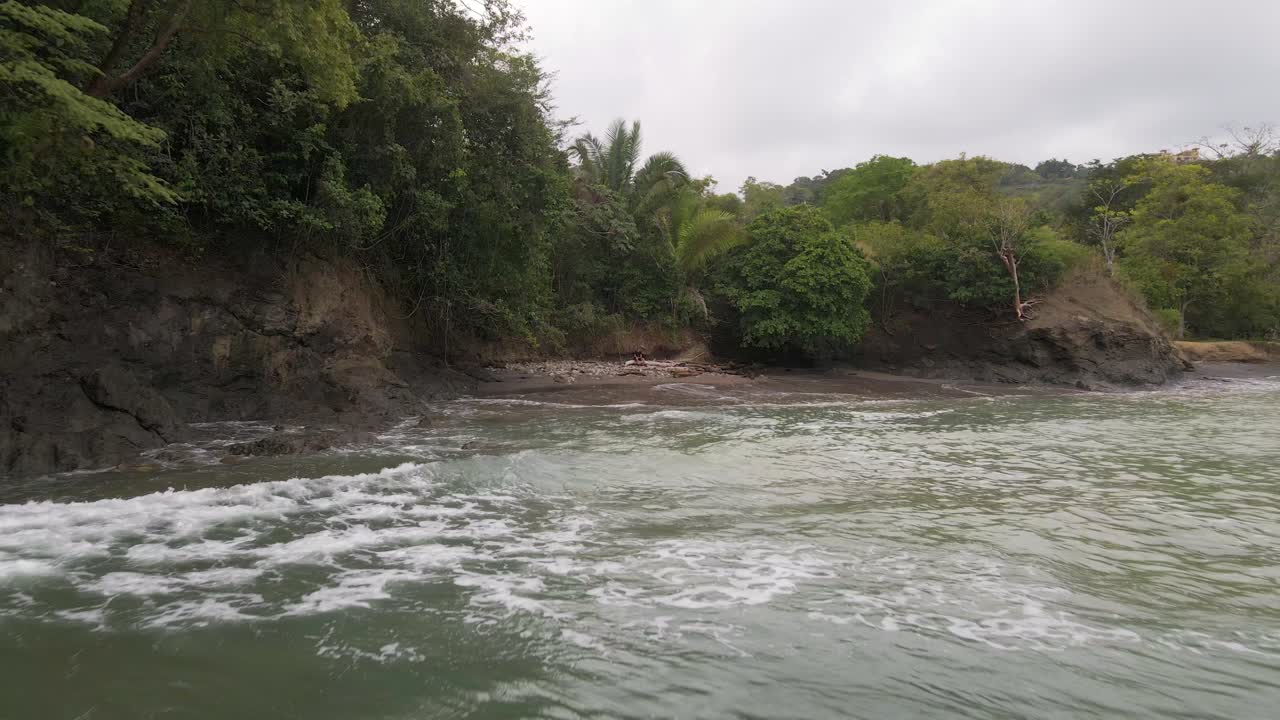 vuelo inverso de drones desde playa la vaca sobrevolando el océano pacífico con vistas a las olas rompiendo en la orilla