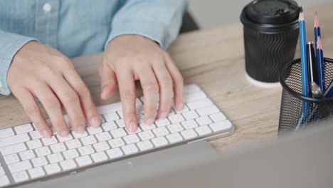 close up hand of a business woman typing keyboard desktop computer on desk office