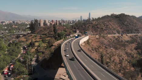 amazing aerial reveal of overpass with traffic at the gates of santiago's concrete jungle, 4k
