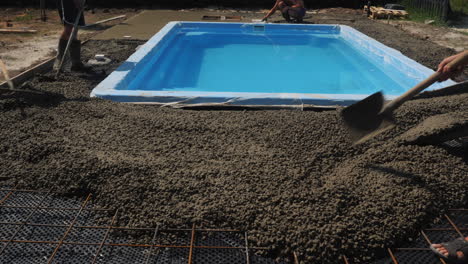 concrete flows down the gutters where workers make paving 2