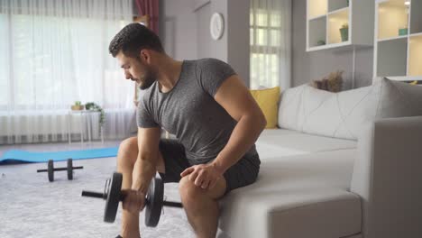 Haciendo-Deporte-En-Casa.-Hombre-En-Forma-Trabaja-Brazos-Con-Pesas.