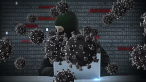 Animation-of-of-macro-covid19-cells-over-man-wearing-balaclava,-using-a-laptop