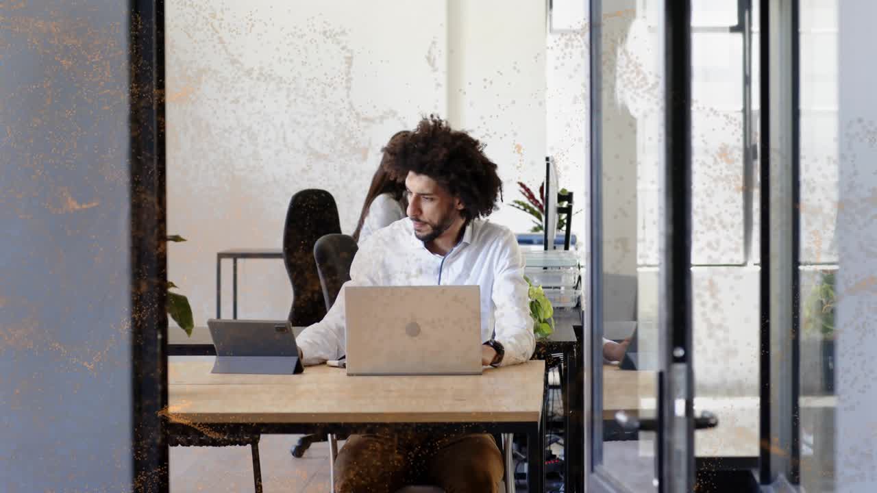 Man typing on laptop, camera pulling back revealing flame overlay fading, showing business space