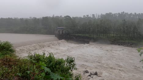 a high angle view of the raging flood waters spewing over a water control dam in nepal