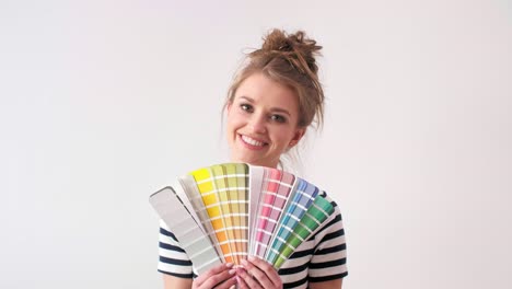 portrait of smiling woman showing paint swatches