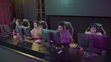 team of four cybersport gamers playing video games in a gaming club 2