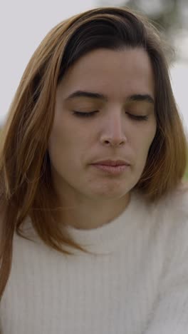 serene woman with eyes closed outdoors