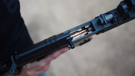persona adjunta cargador con balas en rifle táctico negro, olesko, chequia