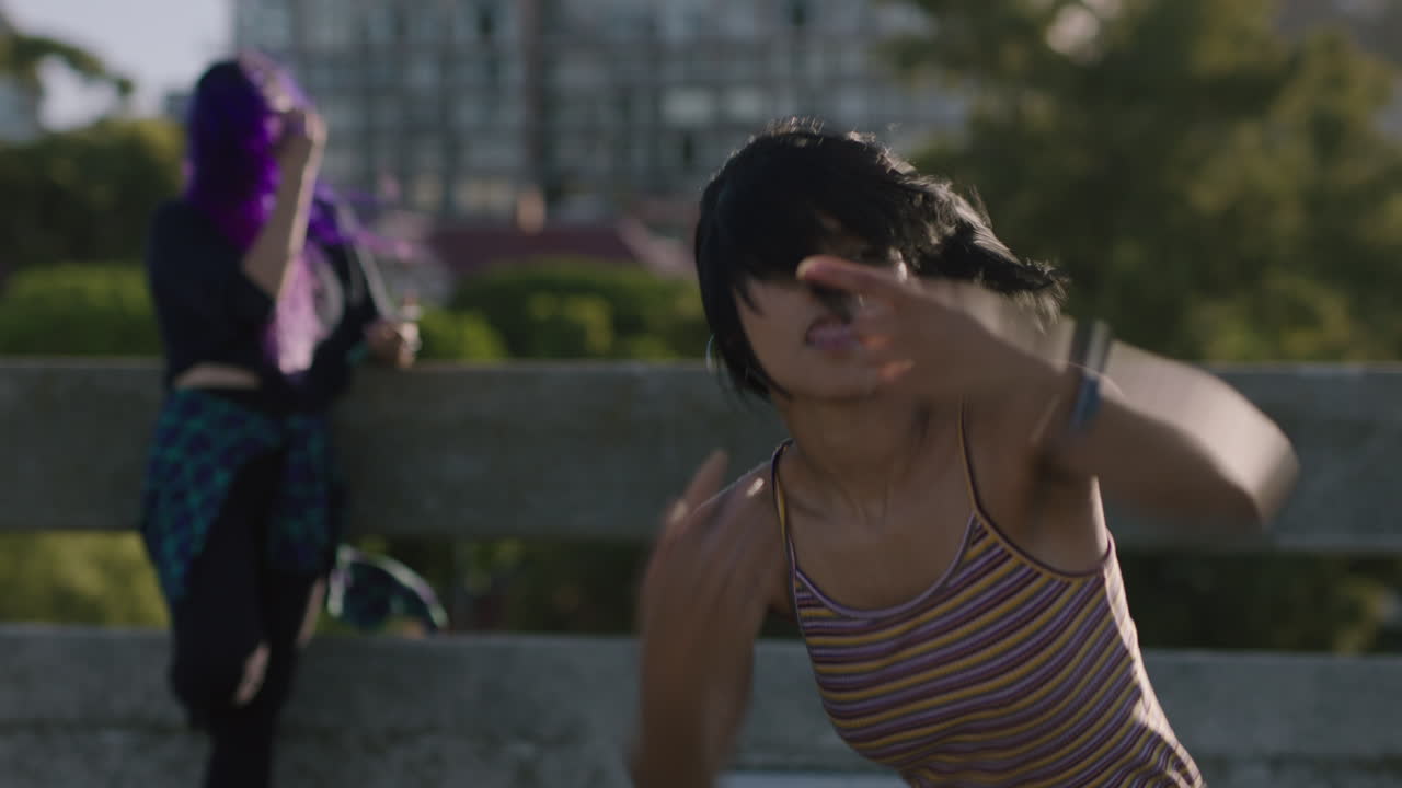 mujer bailarina joven bailarina hispana de hip hop en la ciudad realizando movimientos contemporáneos amigos viendo disfrutando de la danza freestyle urbana niñas multiétnicas relajándose practicando en la calle de cerca