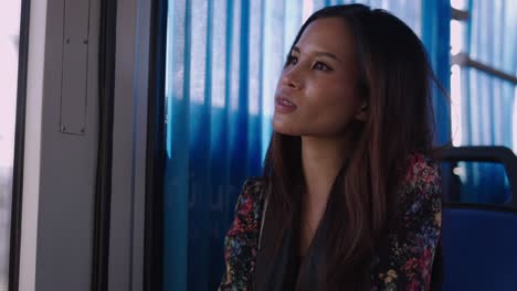 young woman looking out of a window on public transport