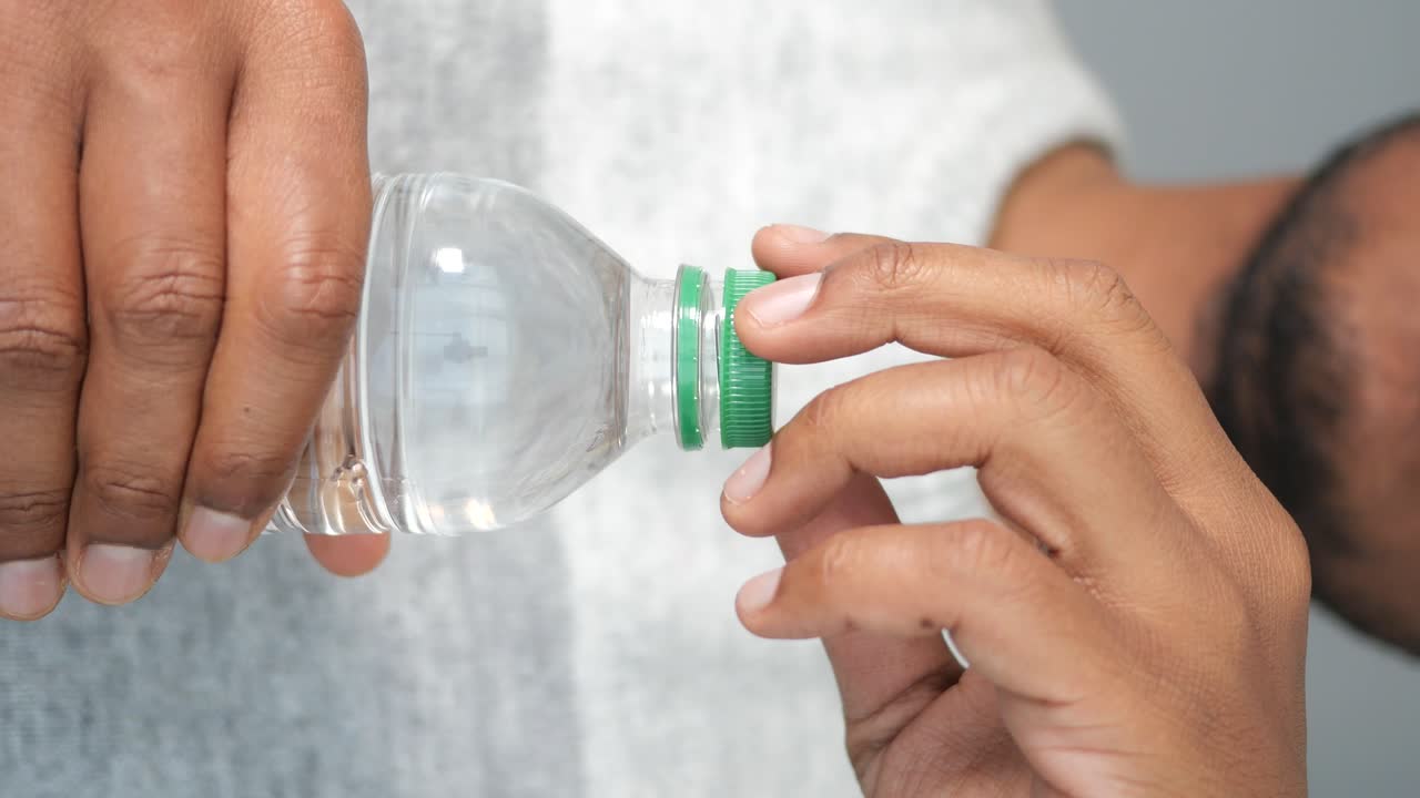 persona que sostiene una botella de agua