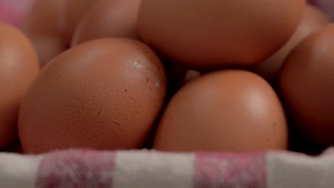 Closeup-of-stack-of-eggs-in-basket-with-checkered-white-and-red-tablecloth