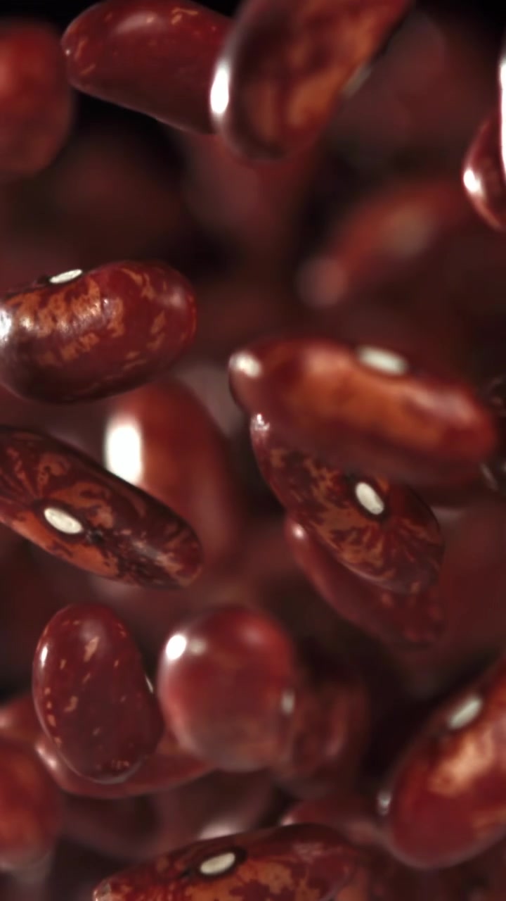 Red Kidney Beans Falling in Slow Motion Against a Black Background