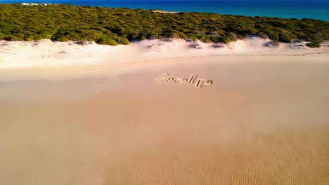 help message written in the sand on a beach