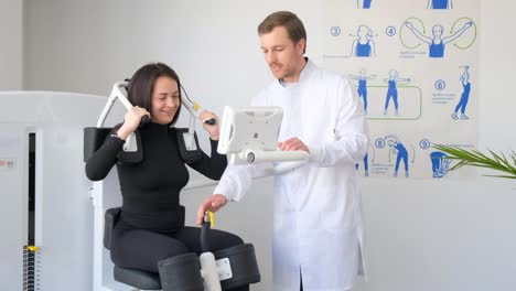 physical therapist assisting patient with exercise machine
