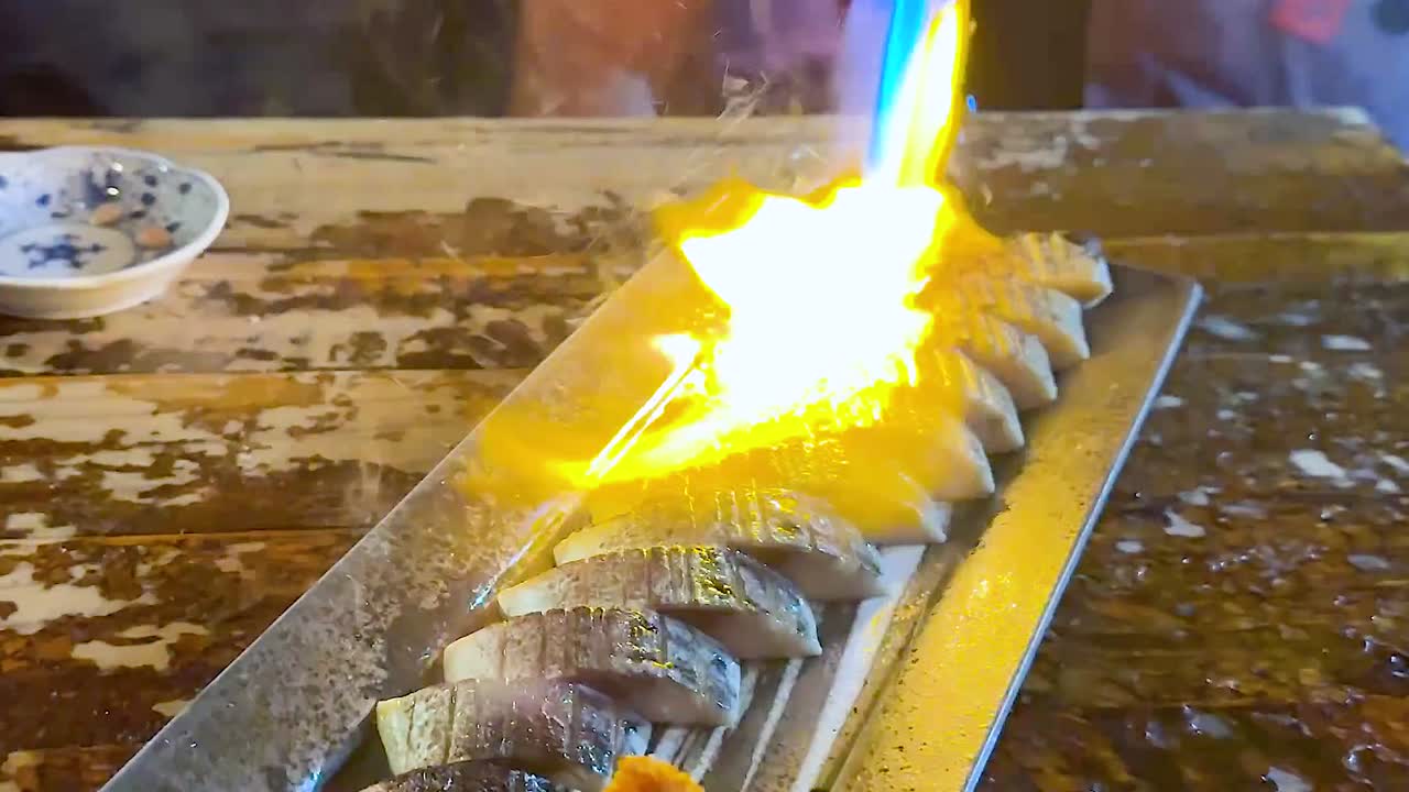 Close-up of sushi being expertly torched with a blue flame for a perfect finish.