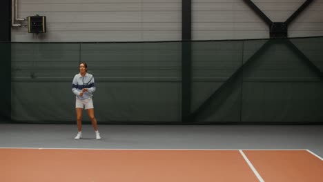 woman playing tennis in indoor court