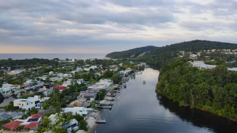 aerial view of luxury accomodations near mossman park and boat sailing at noosa river in qld, australia