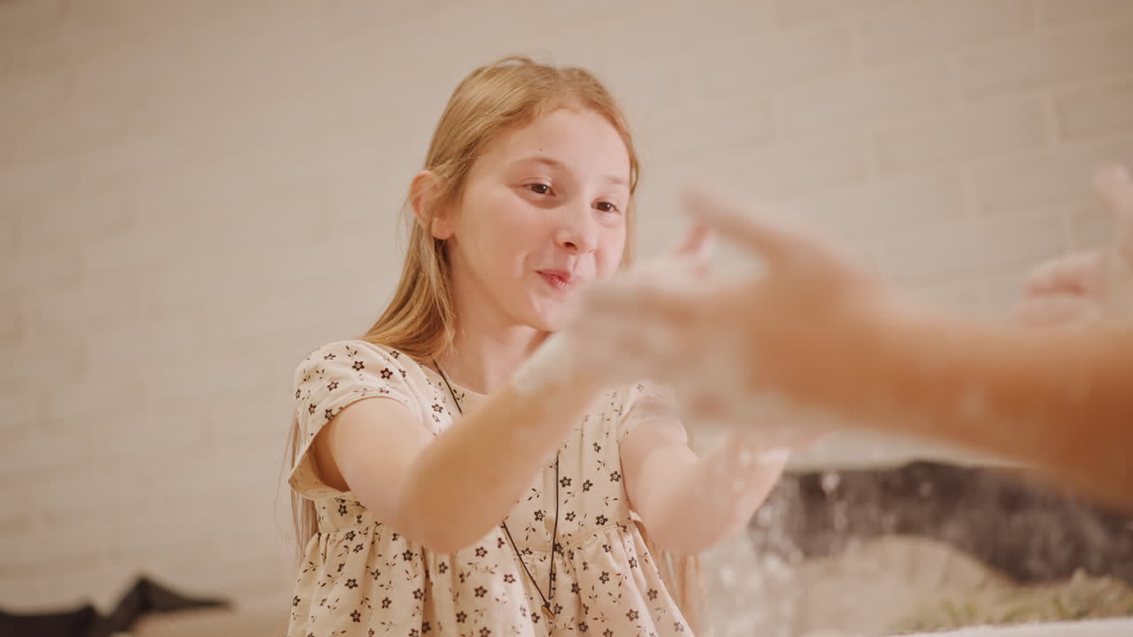 Bambina che impasta con calma l'impasto per la torta di zucca. Ragazza che modella l'impasto con concentrazione in un ambiente tranquillo. Giovane ragazza che impasta diligentemente l'impasto per la torta di zucca tra una luce soffusa e la polvere di farina nell'aria.