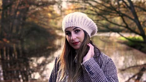 close-up of a caucasian woman in an autumn dress looking down and then smiling at the camera in amsterdam