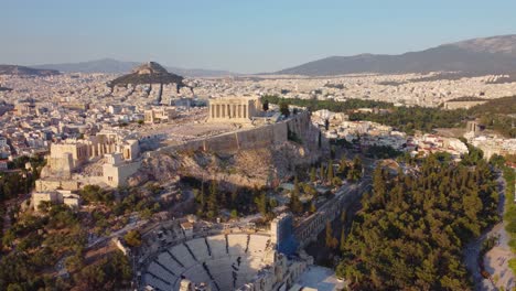 drone aerial shot flying around acropolis ancient city of athens at sunset