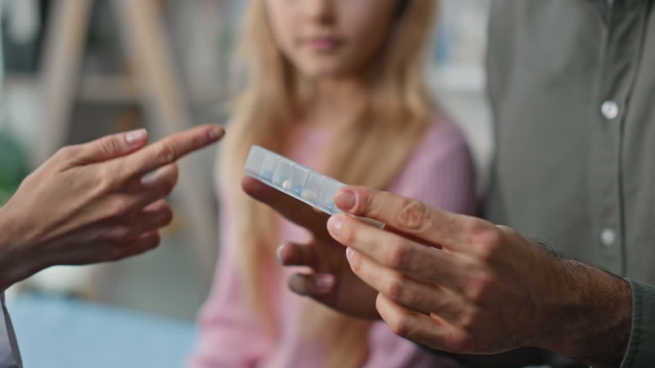 Hands holding pills box in clinic closeup. Cute little girl visit practitioner