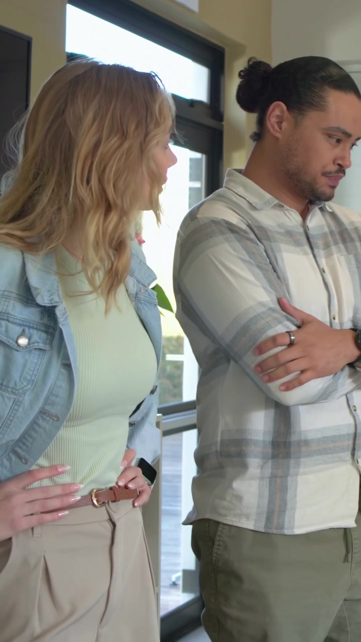 Video verticale: Donna in giacca di jeans che si allunga usando un tablet in ufficio, un uomo si unisce esaminando i grafici.
