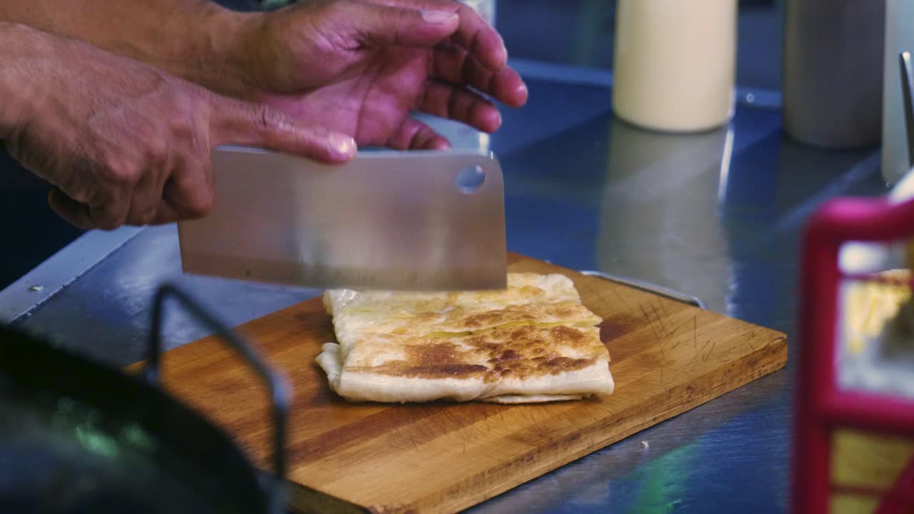 imágenes cinematográficas de cocina de 4k de un chef tailandés preparando un postre tradicional tailandés llamado roti en un mercado callejero en tailandia