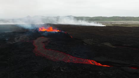 Aerial-landscape-view-over-the-volcano-erupting-at-Litli-Hrutur,-Iceland,-with-lava-and-smoke-coming-up