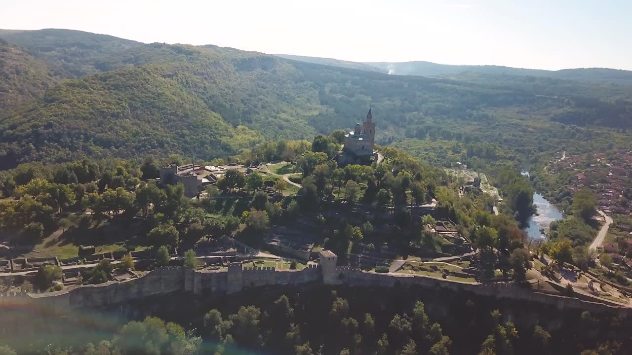 panoramización, grúa hacia abajo, toma de una iglesia en una colina con un sitio arqueológico en veliko tarnovo