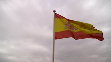 Revelación-En-Cámara-Lenta-Desde-La-Bandera-Española-Hacia-El-Horizonte-De-La-Ciudad-De-Sevilla