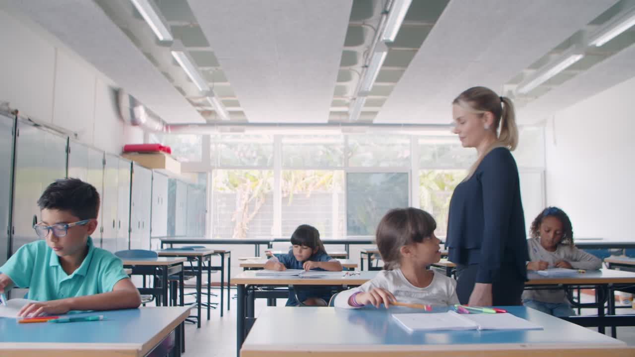 joven maestra de escuela caminando entre escritorios