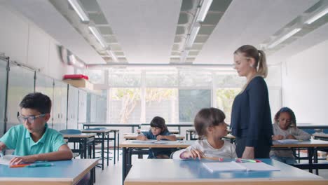 Joven-Maestra-De-Escuela-Caminando-Entre-Escritorios