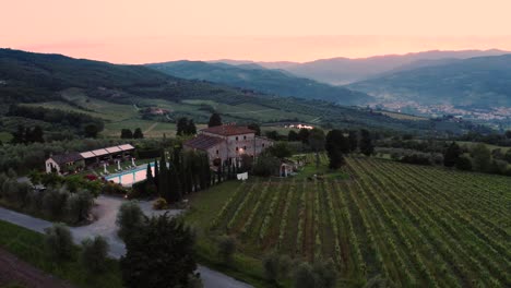 vista aérea de una villa toscana rodeada de viñedos en italia al atardecer, amanecer