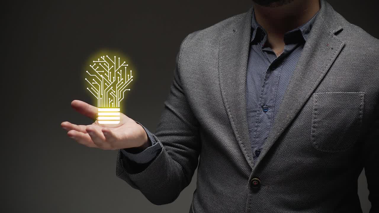 idea concept. a business person shows hologram of electronic yellow light bulb.