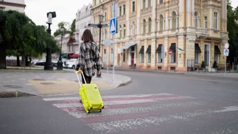 mujer caminando con una maleta en la calle de la ciudad