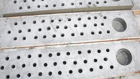 perforated concrete panels with holes where pvc pipes were removed after hardening