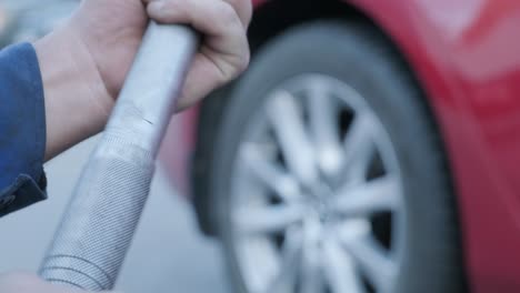 mechanic using a torque wrench socket and extension on the lug nuts of a truck wheel.