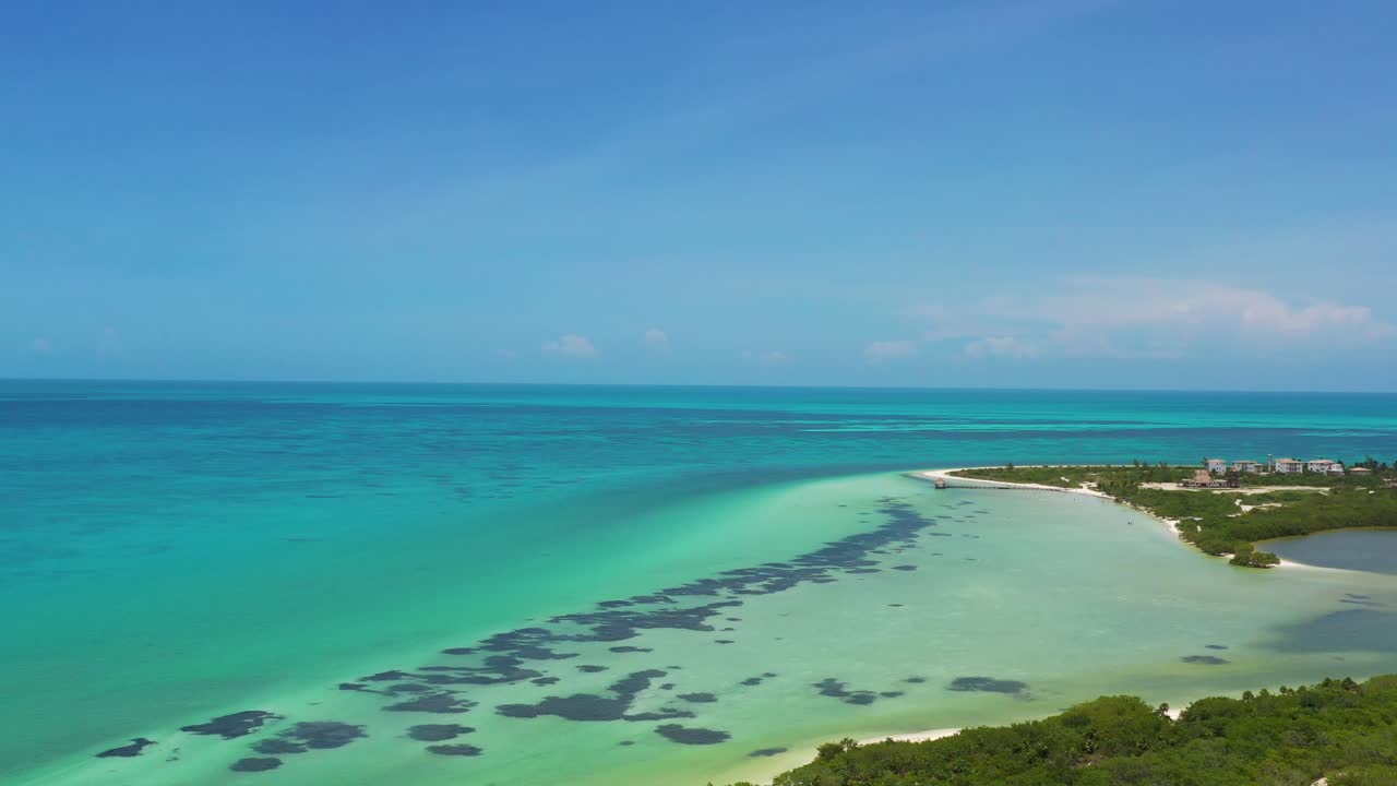 Ripresa aerea del Mar dei Caraibi che rivela una piccola penisola con condomini.