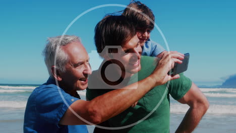 animación de iconos de cámara sobre hombre caucásico con hijo y nieto usando teléfono inteligente.