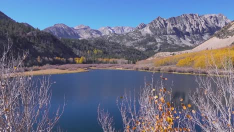 una toma amplia de colores otoñales junto a un lago de sierra alta
